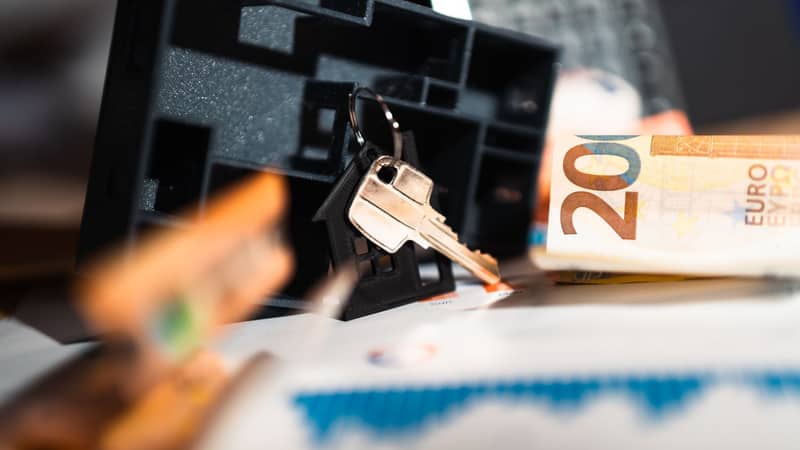 Raktai ir eurų banknotai ant stalo